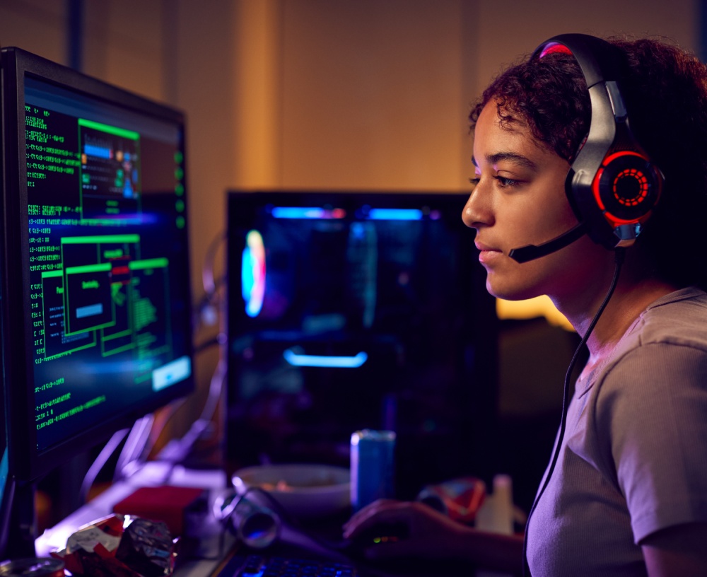 Female Teenage Hacker Sitting in Front of Computer Screens Bypassing Cyber Security